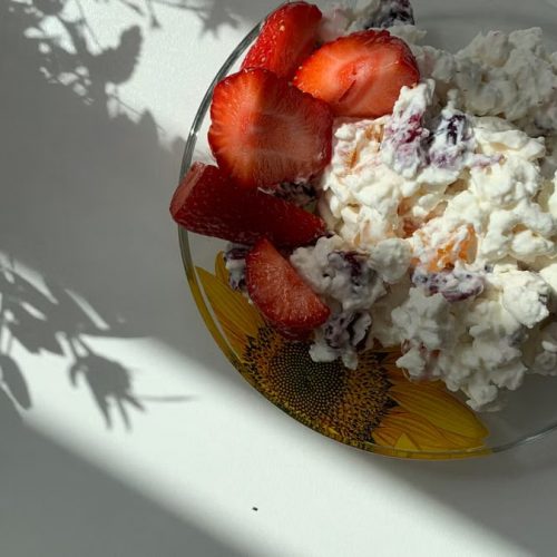A sunlit plate of strawberries and cottage cheese perfect for breakfast.