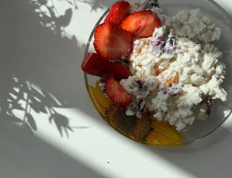 A sunlit plate of strawberries and cottage cheese perfect for breakfast.